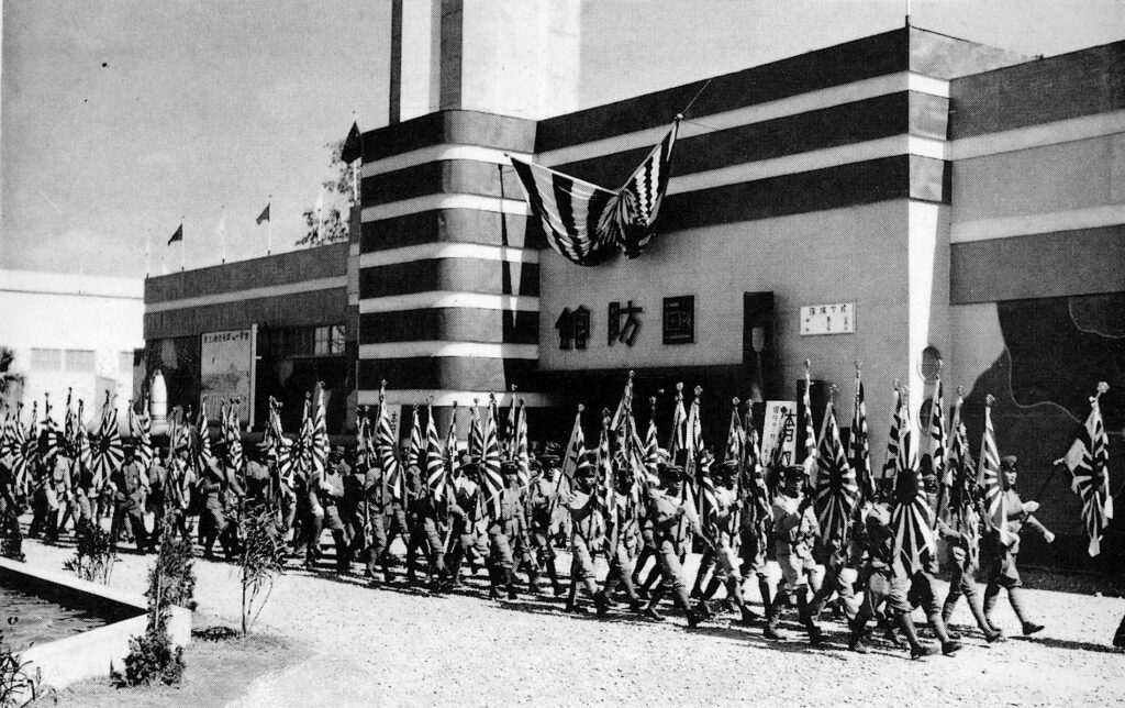 Photograph of a parade of soldiers in front of the National Defense Pavilion, 1935 Taiwan Exposition. (Source: Shisei Shijisshūnen Kinen Taiwan Hakurankai shashinchō 始政四十周年記念台湾博覧会写真帖 [1935] (Tokyo: Kokusho Kankōkai, 2012.))